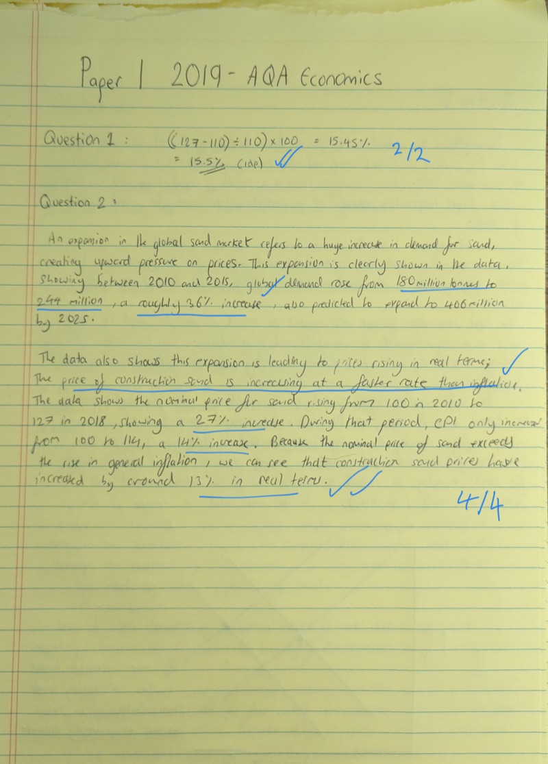 First page of a marked AQA Paper 1, with per-question marks and handwritten comments added in blue